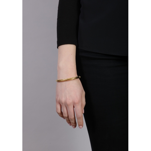 5 - UNO A ERRE: AN 18K GOLD BANGLE  Of hinged scrolled design, in 18K gold, maker’s mark and Italian reg... 