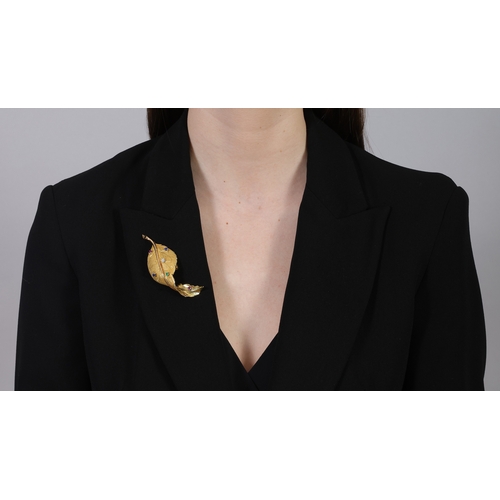 56 - A GEM-SET AND DIAMOND BROOCH  The stylised textured and polished gold leaf, highlighted with circula... 