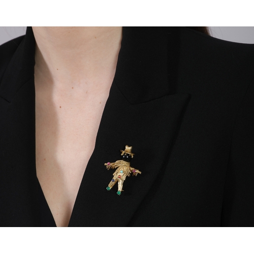 79 - A GEM-SET NOVELTY BROOCH  The stylised textured gold scarecrow with onyx head, accented with circula... 