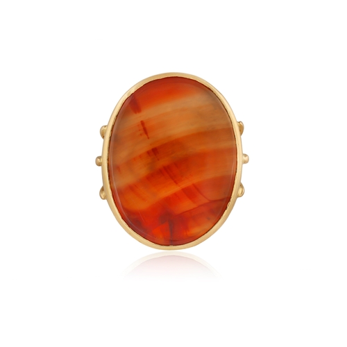 91 - A CARNELIAN RING  The closed-back oval-shaped carnelian, within collet-setting, to a multi-furcated ... 