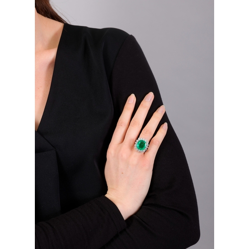 117 - AN EMERALD AND DIAMOND CLUSTER RING  The cushion-shaped emerald, weighing approximately 8.80cts, wit... 