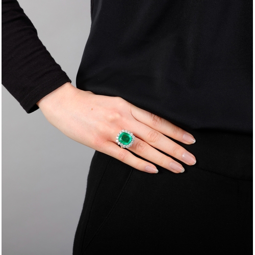 117 - AN EMERALD AND DIAMOND CLUSTER RING  The cushion-shaped emerald, weighing approximately 8.80cts, wit... 