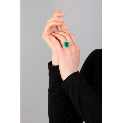 117 - AN EMERALD AND DIAMOND CLUSTER RING  The cushion-shaped emerald, weighing approximately 8.80cts, wit... 