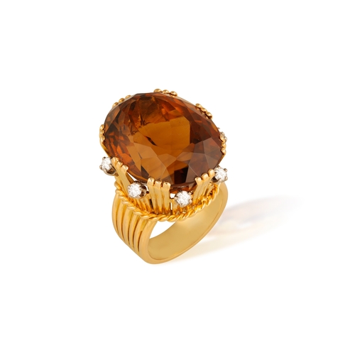 73 - STERLÉ: A CITRINE AND DIAMOND COCKTAIL RING, CIRCA 1950  The raised oval-shaped citrine weighing app... 