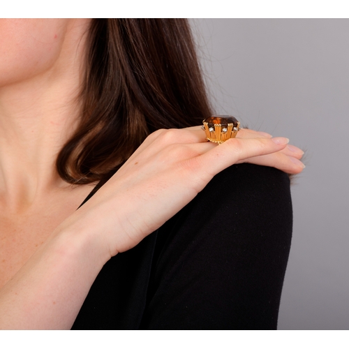 73 - STERLÉ: A CITRINE AND DIAMOND COCKTAIL RING, CIRCA 1950  The raised oval-shaped citrine weighing app... 
