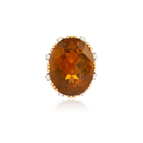 73 - STERLÉ: A CITRINE AND DIAMOND COCKTAIL RING, CIRCA 1950  The raised oval-shaped citrine weighing app... 