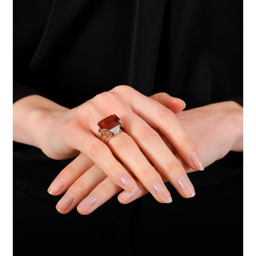 74 - A CITRINE AND DIAMOND DRESS RING, CIRCA 1950  Set horizontally, the cut-cornered rectangular citrine... 