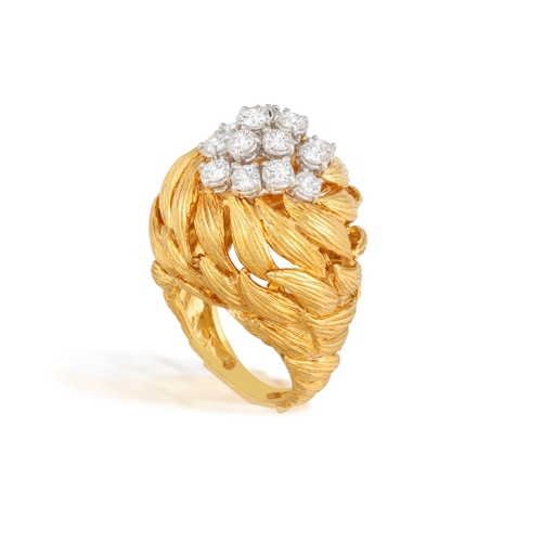81 - A GOLD AND DIAMOND COCKTAIL RING   The openwork raised mount composed of scrolled textured leaf-shap... 