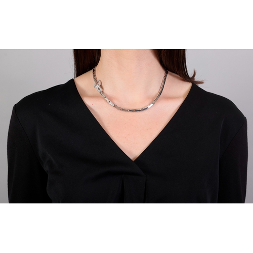 88 - CARTIER: A DIAMOND 'AGRAFE' NECKLACE  Composed of a fancy-link chain, centring a hook-and-loop clasp... 