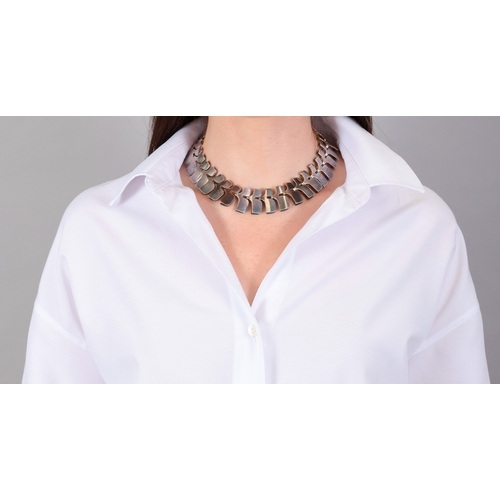 91 - GEORG JENSEN, DESIGNED BY IBE DAHLQUIST: A SILVER NECKLACE, CIRCA 1960  Composed of fancy fold-over ... 