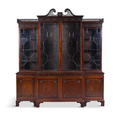 530 - A GEORGE III MAHOGANY FOUR DOOR BREAKFRONT BOOKCASE,  of architectural form with broken swan‑neck pe... 