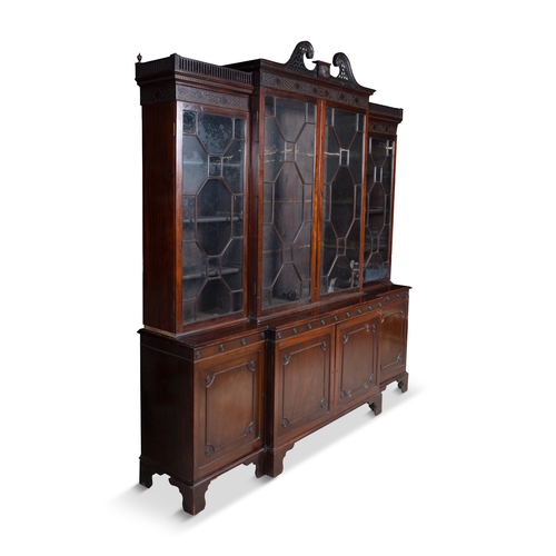 530 - A GEORGE III MAHOGANY FOUR DOOR BREAKFRONT BOOKCASE,  of architectural form with broken swan‑neck pe... 