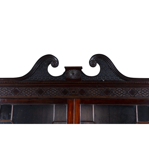 530 - A GEORGE III MAHOGANY FOUR DOOR BREAKFRONT BOOKCASE,  of architectural form with broken swan‑neck pe... 