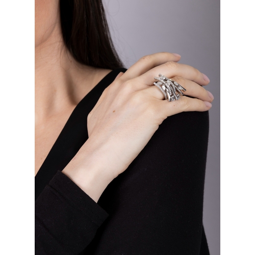 118 - M. & CO.: A RETRO DIAMOND RING, CIRCA 1950  The stepped, fan-shaped mount comprising seven knife-edg... 