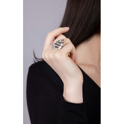 118 - M. & CO.: A RETRO DIAMOND RING, CIRCA 1950  The stepped, fan-shaped mount comprising seven knife-edg... 