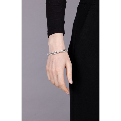 119 - A DIAMOND BRACELET, CIRCA 1965  The flexible strap designed as three double row of graduated brillia... 