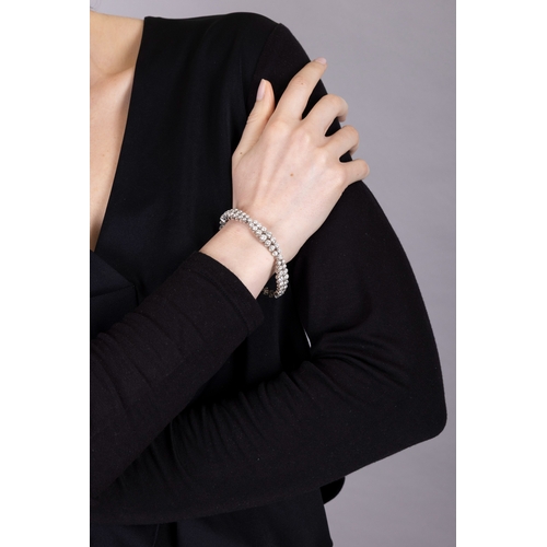 119 - A DIAMOND BRACELET, CIRCA 1965  The flexible strap designed as three double row of graduated brillia... 