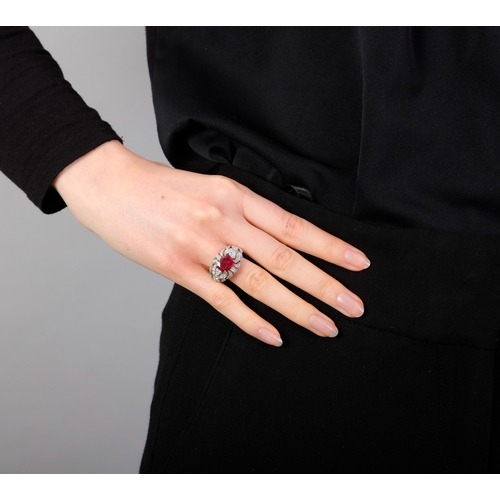 120 - A RUBY AND DIAMOND DRESS RING   Centring a claw-set cushion-shaped ruby weighing approximately 2.60c... 