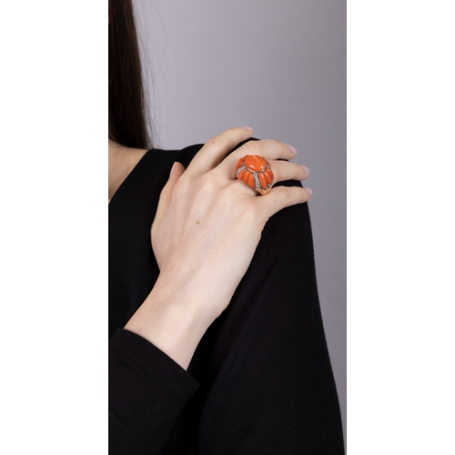 198 - TONY NY: A RETRO CORAL AND DIAMOND RING  The domed bombé mount centring an oval Corallium rubrum cor... 