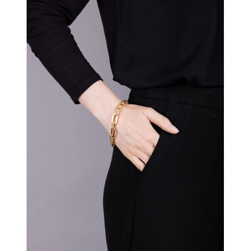 75 - A GOLD BRACELET, CIRCA 1960  Composed of oval polished gold links, interspersed by textured gold rop... 