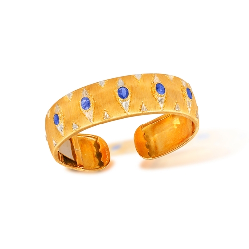 76 - MARIO BUCCELLATI: A BI-COLOURED GOLD AND SAPPHIRE BANGLE, CIRCA 1955  The cuff set with oval-shaped ... 
