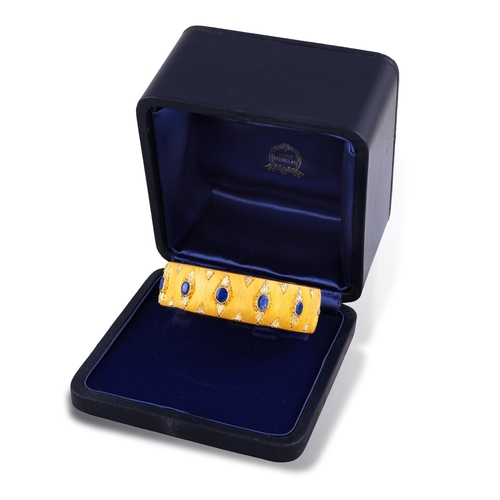 76 - MARIO BUCCELLATI: A BI-COLOURED GOLD AND SAPPHIRE BANGLE, CIRCA 1955  The cuff set with oval-shaped ... 