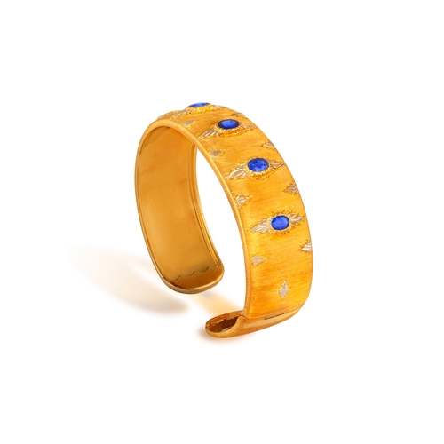 76 - MARIO BUCCELLATI: A BI-COLOURED GOLD AND SAPPHIRE BANGLE, CIRCA 1955  The cuff set with oval-shaped ... 