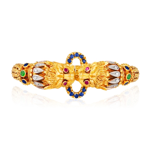 82 - LALAOUNIS: A GOLD AND GEM-SET BANGLE  Of woven foxtail linking, terminating in lion's head motifs at... 