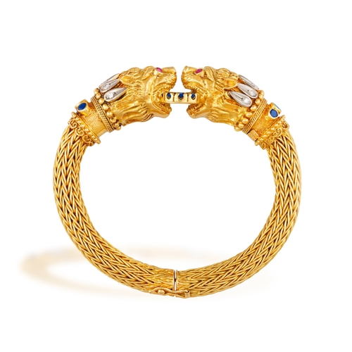 82 - LALAOUNIS: A GOLD AND GEM-SET BANGLE  Of woven foxtail linking, terminating in lion's head motifs at... 