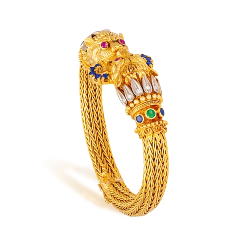 82 - LALAOUNIS: A GOLD AND GEM-SET BANGLE  Of woven foxtail linking, terminating in lion's head motifs at... 