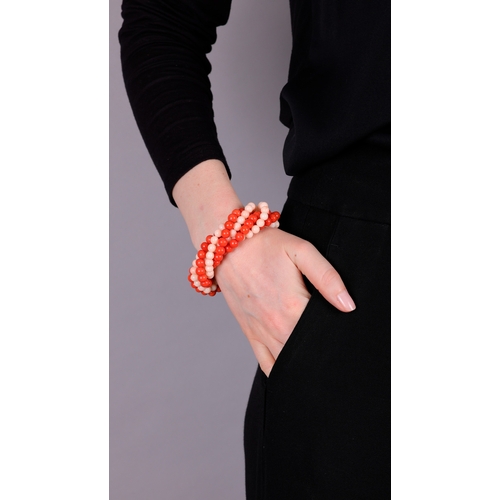 91 - A CORAL AND GOLD BRACELET, CIRCA 1970  Of torsade design, set with six strands of red and angel's sk... 