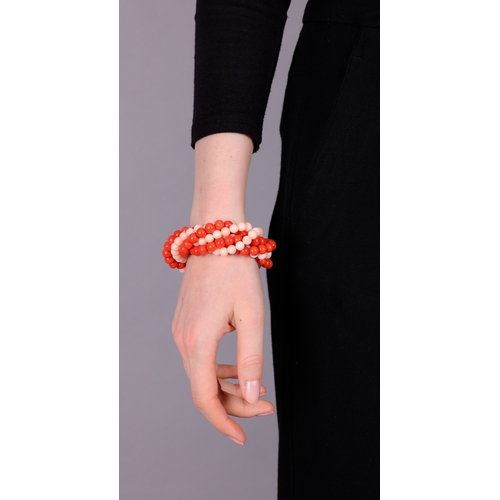 91 - A CORAL AND GOLD BRACELET, CIRCA 1970  Of torsade design, set with six strands of red and angel's sk... 