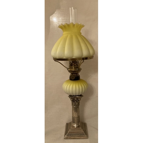 130 - An early peg lamp with green milk glass shade, height including chimney 47cm