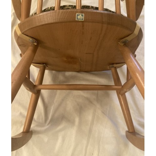 33 - Ercol light oak rocking chair, original cushion in need of new padding.