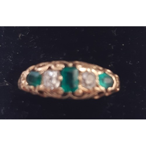 106 - Unmarked yellow metal emerald and diamond ring. Two oval emeralds, 4.00mm x 2.5mm approx. One centre... 