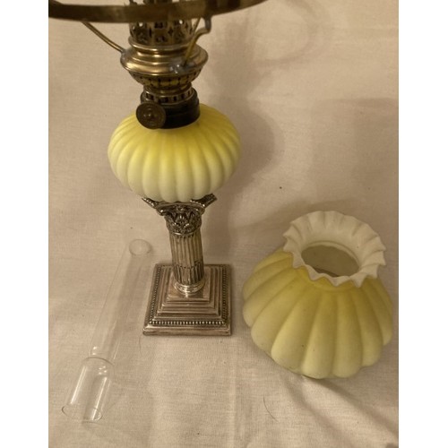 130 - An early peg lamp with green milk glass shade, height including chimney 47cm