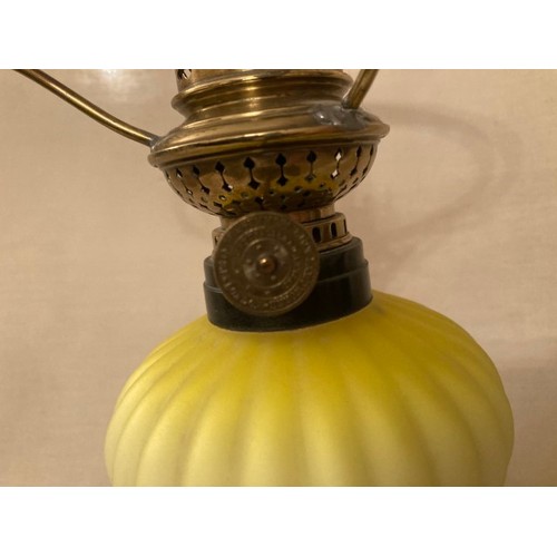 130 - An early peg lamp with green milk glass shade, height including chimney 47cm