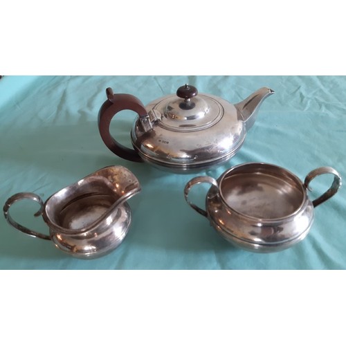 149 - A non-conforming but similar three piece tea set. Tea pot containing crest retailed by Harrods. Milk... 