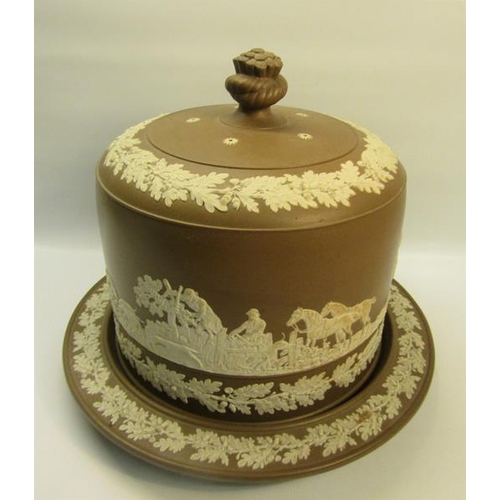 214 - A 19c Dudson cheese dish and cover decorated on a brown ground in relief with hunting scene and with... 