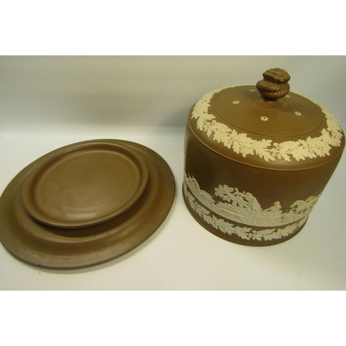 214 - A 19c Dudson cheese dish and cover decorated on a brown ground in relief with hunting scene and with... 
