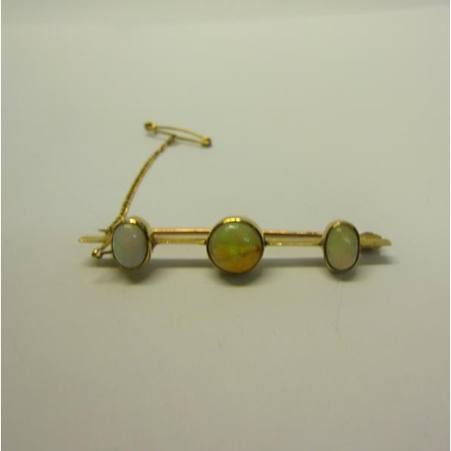 201 - A gold three stone Opal set bar brooch - 4.5cms l.