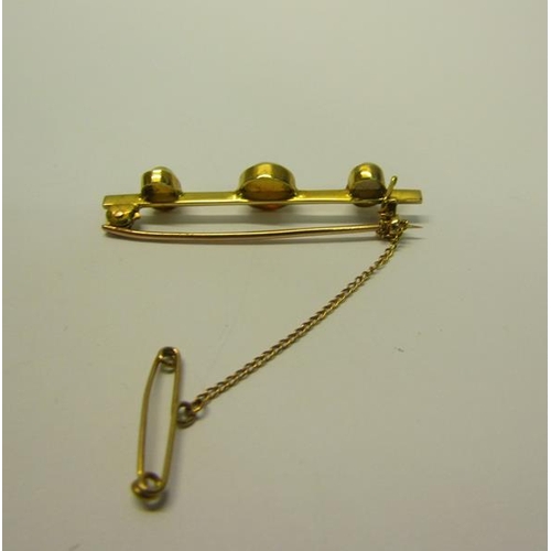 201 - A gold three stone Opal set bar brooch - 4.5cms l.