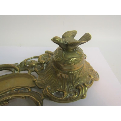 40 - A late Victorian cast brass ink stand with single well under a domed cover with bird finial, with pe... 