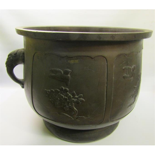 46 - A 19c Oriental patinated bronze jardinere of bulbous form with Elephant trunk side handles and panel... 