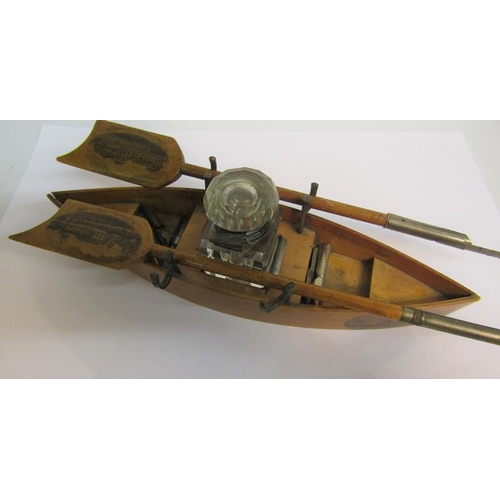 94 - An early 20c Mauchline Ware rowing boat single bottle inkstand, a blade of the oar with printed pane... 