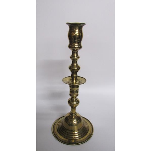 56 - An 18c bronze bell base candlestick with a knop double column with central drip pan and baluster soc... 