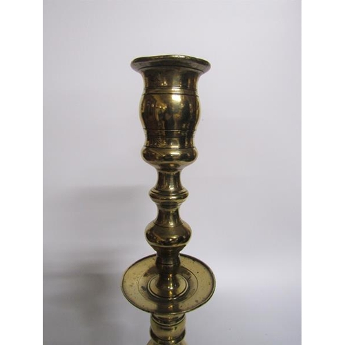 56 - An 18c bronze bell base candlestick with a knop double column with central drip pan and baluster soc... 