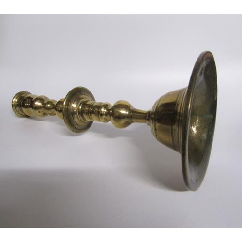 56 - An 18c bronze bell base candlestick with a knop double column with central drip pan and baluster soc... 