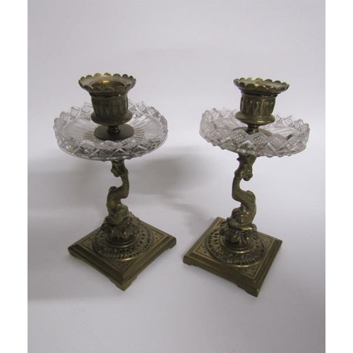 62 - A pair of late 19c ormolu candlesticks with dolphin columns, cut glass drip pans supported on square... 