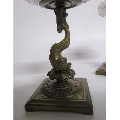 62 - A pair of late 19c ormolu candlesticks with dolphin columns, cut glass drip pans supported on square... 